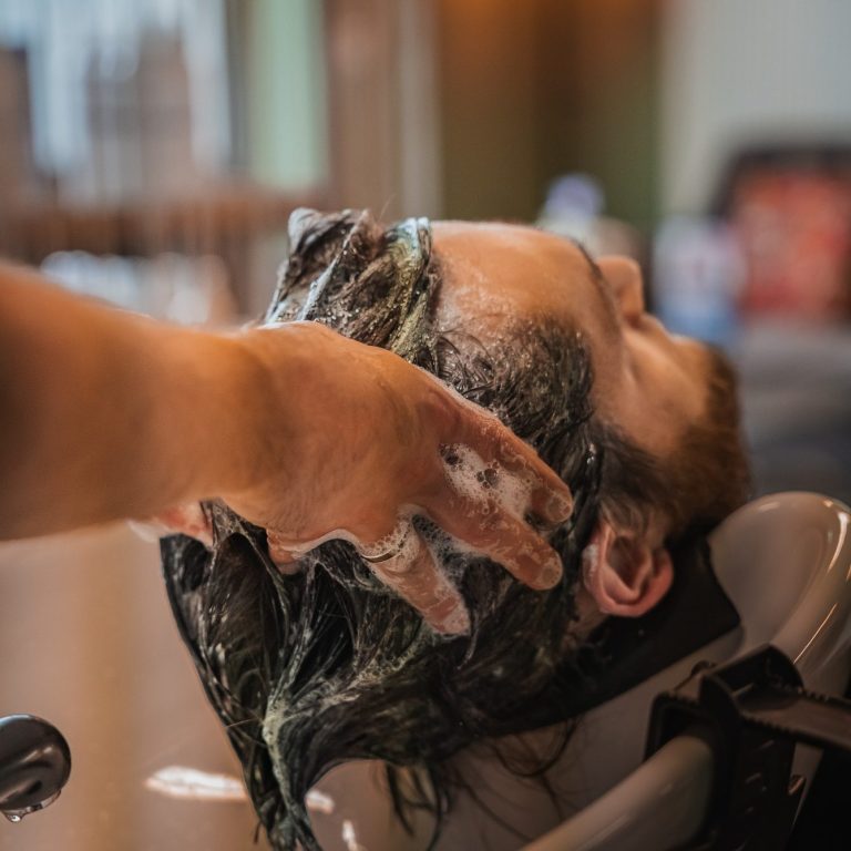 Hand hält einen silbernen, retro Fotoapparat mit Prägung.