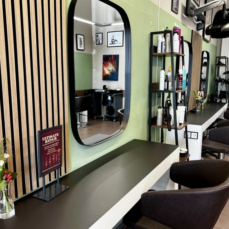 Nahaufnahme eines schneidenden Haarschnitts mit Tätowierungen und einem Kamm.